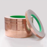 Close-up of conductive adhesive backing on double-sided copper foil for electrical grounding